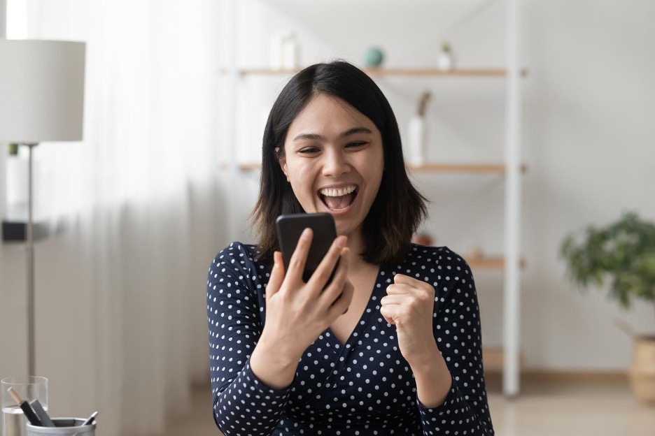 happy-woman-looking-at-smartphone-rewarded-videos-concept